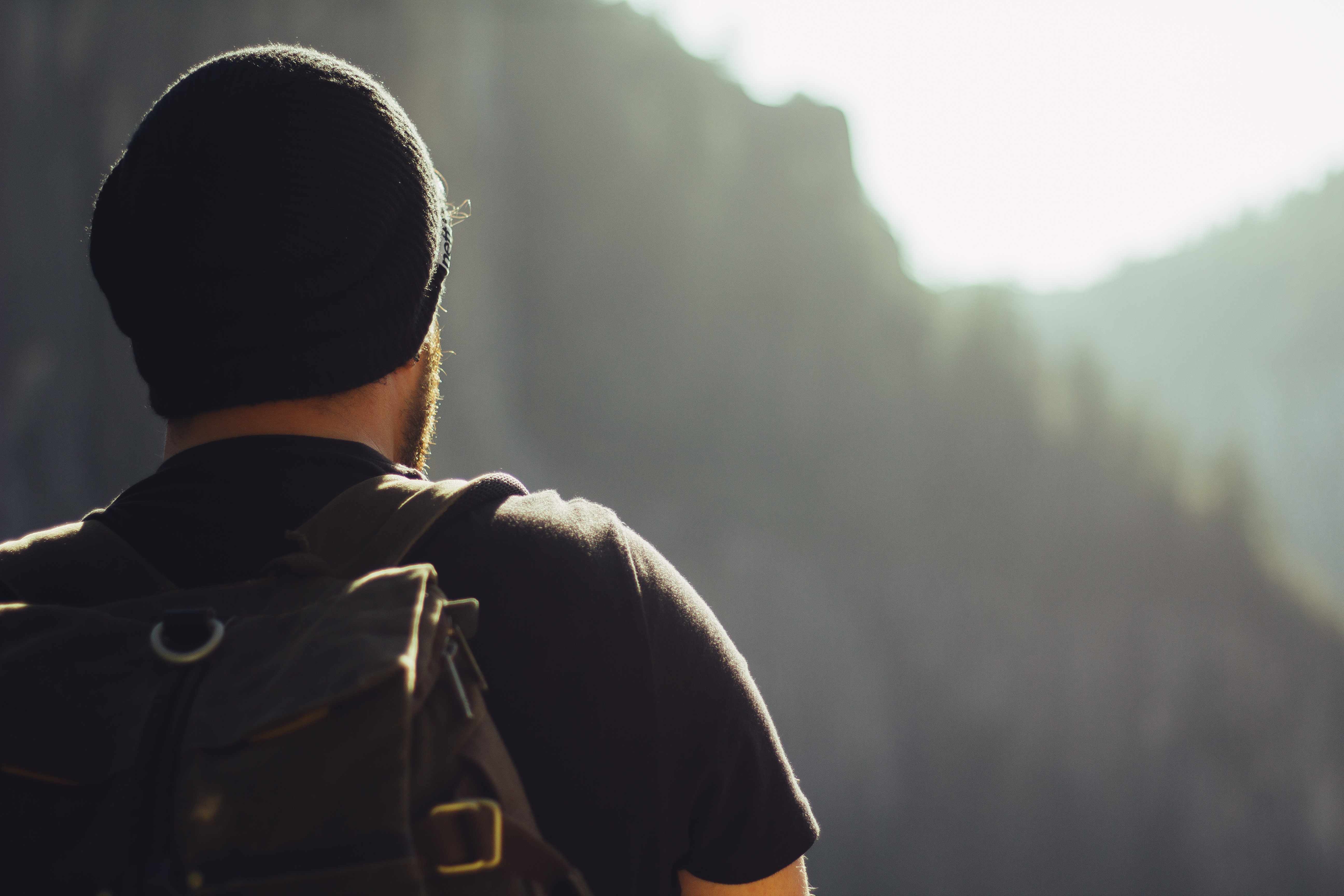 Person with backpack looking at mountains, representing leadership vision and determination